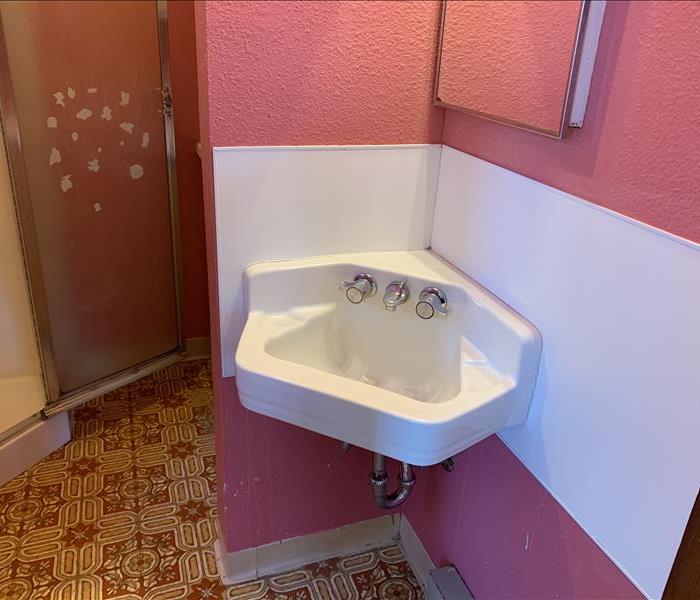 Clean sink, clean white back splash and pink walls
