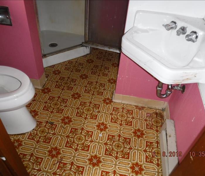 Dirty sink, marked white back splash and pink walls