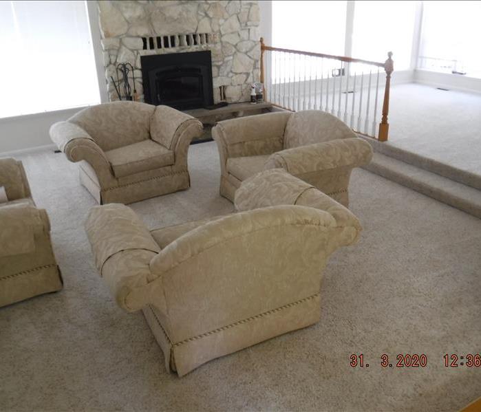 Clean room with white fire place, white carpet, and four chairs